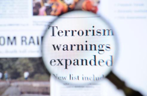 Magnifying Glass Over Terrorism Headline (Stock Image)