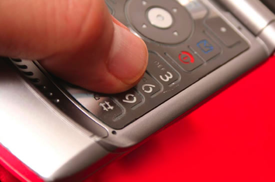 Thumb on Cell Phone Keypad (Stock Image)