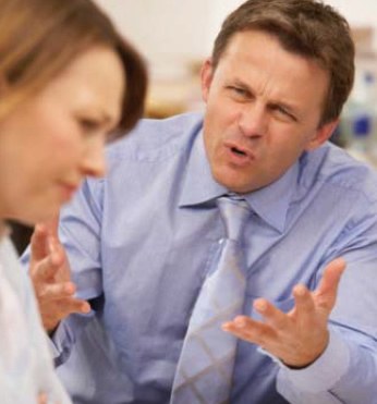 Angry Man Talking to a Woman in the Workplace (Stock Image)